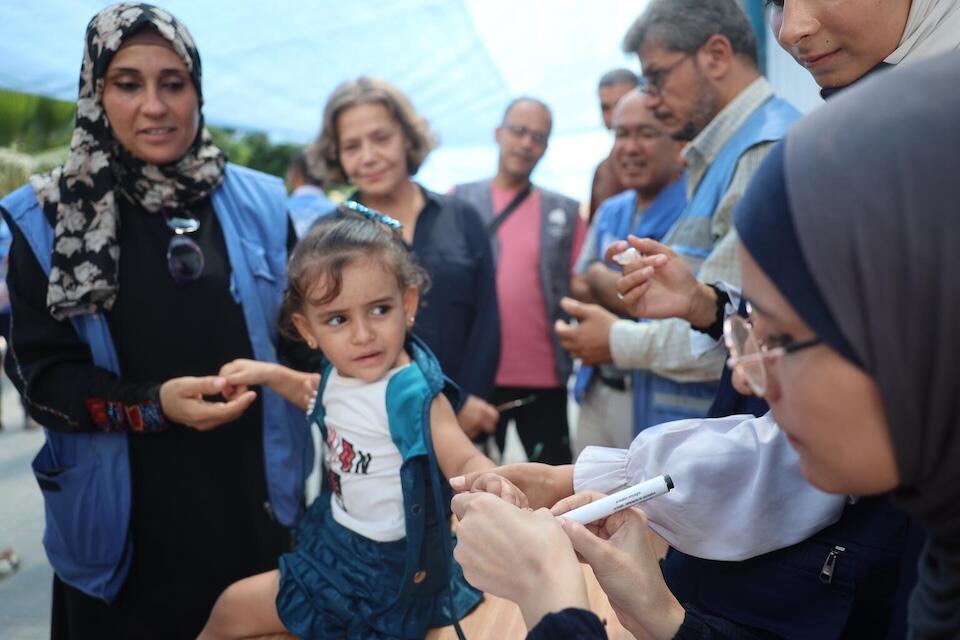 A health worker inks a child's finger to show the child has received the polio vaccine as part of a UNICEF-supported emergency immunization campaign in the Gaza Strip. 