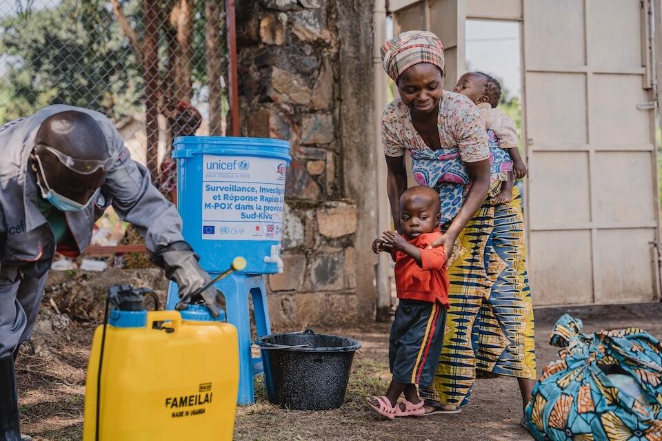 Neema and her young children, Jordan, 3, and Joseline, 1, undergo feet disinfection procedures as they are discharged following a week's treatment at the UNICEF-supported mpox isolation and treatment unit at Lwiro Hospital in South Kivu province, DRC, on Sept. 12, 20024.