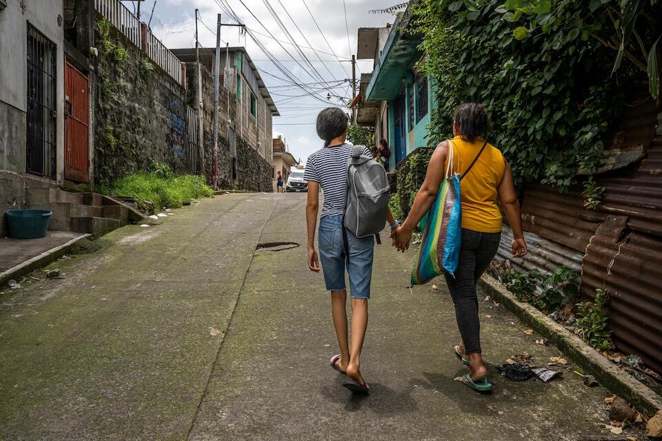 Luna and her mother walk hand-in-hand in Guatemala. 