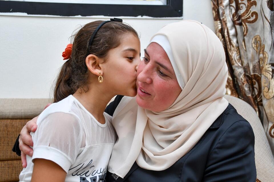 On Sept. 26, 2024, Mira 8, kisses her mother Fadia, 49, in their house in Beit Sawa village in Rural Damascus, Syria, where the family fled to escape violent conflict in Beirut.