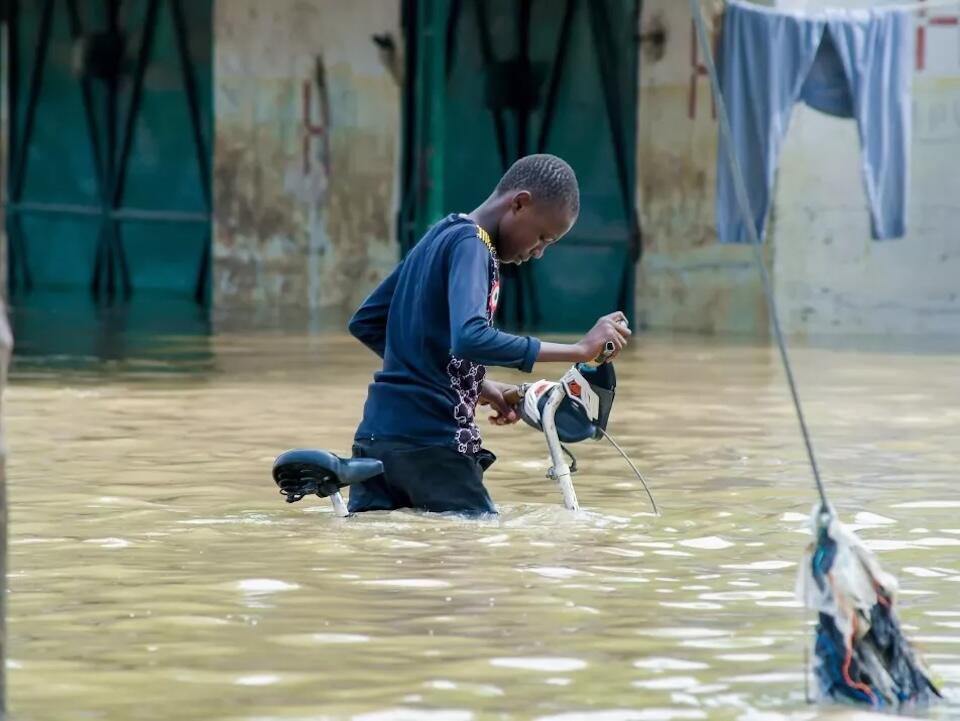 A boy steers his bicycle through floodwaters in Maiduguri, Nigeria.