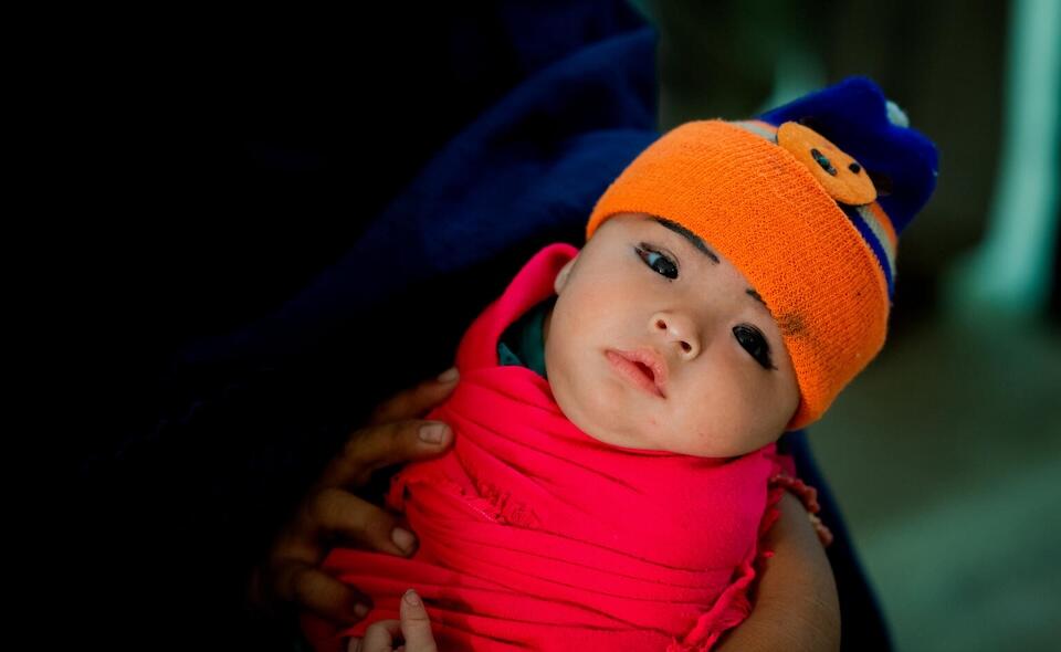 A woman cradles a child in the waiting room of Jannat Gul Hospital in the suburb of Gujro, Pakistan. As the only health facility in the area, the hospital sees a large number of children and families every day, performing many services including birth registration. 