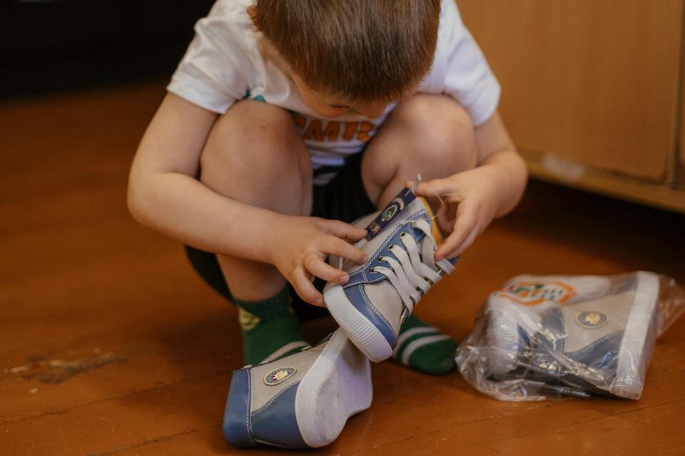 In Kharkiv, Ukraine, a 3-year-old boy examines new shoes his family purchased with financial assistance from UNICEF.