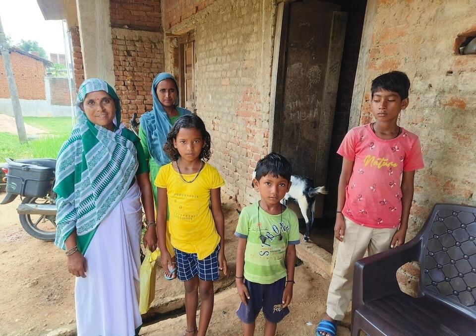 A UNICEF-supported social health activist, far left, with a family in Jharkhand, India.