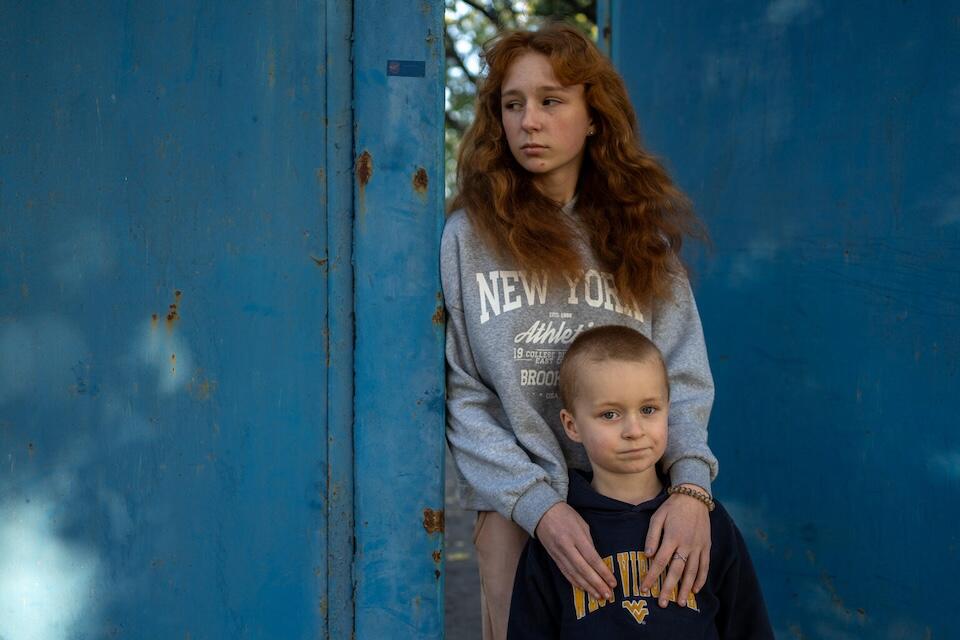 Siblings share a quiet moment outside their rented house in in Khotimlya, Kharkiv, Ukraine on Oct. 23, 2024.