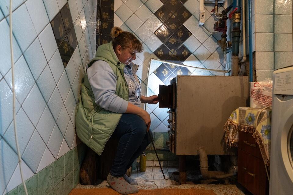 On Oct. 23, 2024 in Khotimlya, Kharkiv region, Ukraine, Katya tends to the boiler that heats her family's rented house.