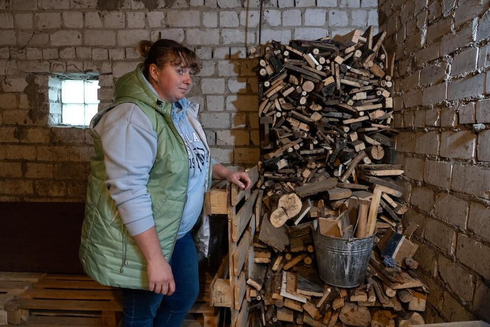 On Oct. 23, 2024 in Khotimlya, Kharkiv region, Ukraine, Katya inspects the firewood she has prepared to keep her family warm during the winter.