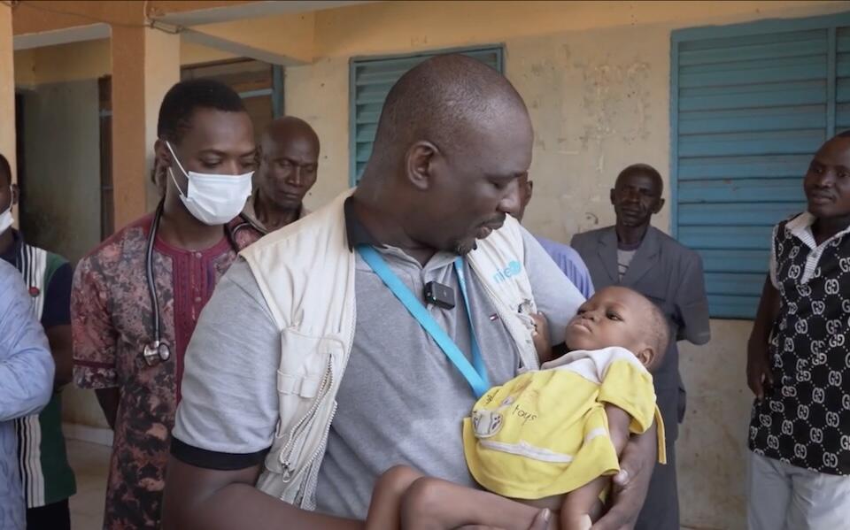 UNICEF Emergency WASH Officer Daouda Sanou cradles 2-year-old Maiga, who is suffering from severe acute malnutrition, at a UNICEF-supported health and nutrition center in Arbinda, northern Burkina Faso, one of the hardest-to-reach places for humanitarian responders.