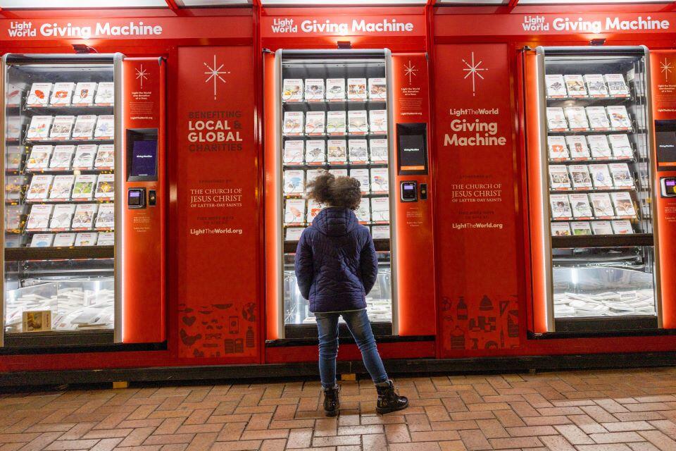 A young girl browses a Light the World Giving Machine