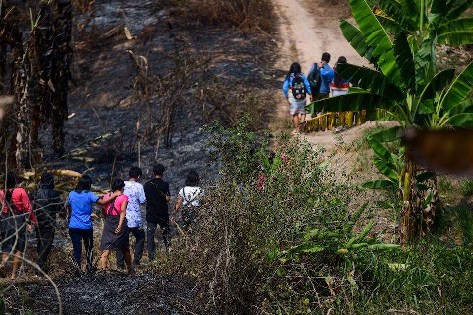 A group of schoolchildren walk through an area of Peru devastated by wildfires. Prolonged drought is impacting access to safe water, health care and disrupting education.