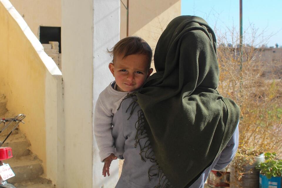 A mother holds her baby son in Obada village, Rural Damascus, Syria on Dec. 17, 2024.