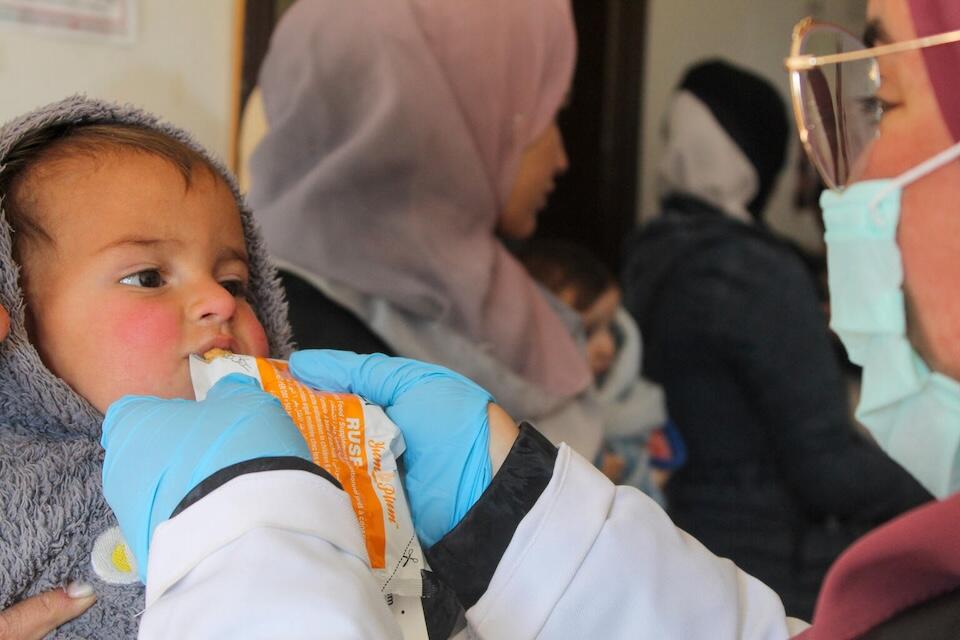 A health worker from a UNICEF-supported health and nutrition mobile team provides 1-year-old Morei with preventive food supplements in Obada village, Rural Damascus, Syria on Dec. 15, 2024.