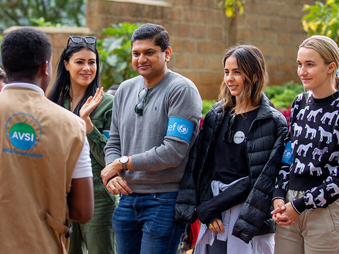 Maybe a shorter version: Four UNICEF Next Generation members meet with the manager of a tea plantation to discuss creating child-friendly workplaces in Rwanda.