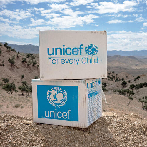 UNICEF 'for every child' supply boxes on a cliff in the foreground.