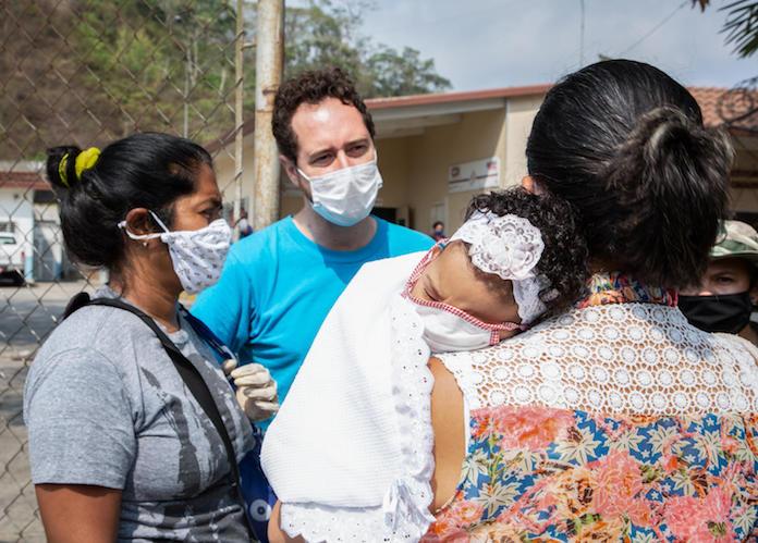 UNICEF water, sanitation and hygiene specialist David Símon talks with women about COVID019 prevention measures at a health clinic on the outskirts of Caracas, Venezuela on April 22, 2020. 