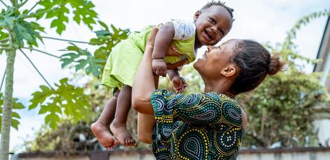 Ngozi Chike plays with her 6-month-old son Chidiebube at Otuocha Primary Healthcare Center, Anambra State, Nigeria, where the child received receiving a dose of Vitamin A through a UNICEF-supported program.