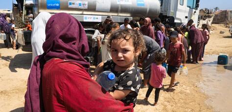 Aseel, one-year-old, holding a bottle of water filled from a UNICEF-supported water tank in Deir al-Balah, in the Gaza Strip, thanks to the government of Australia and Sweden.