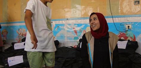 UNICEF early child development officer Fairoo Abuz Warda shares a moment with a child in the Gaza Strip.