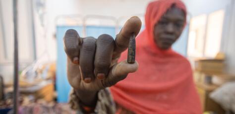 Samah holds the bullet that was removed from her 8-year-old daughter Fatima's head at UNICEF-supported Aljekaika hospital in northern Sudan..