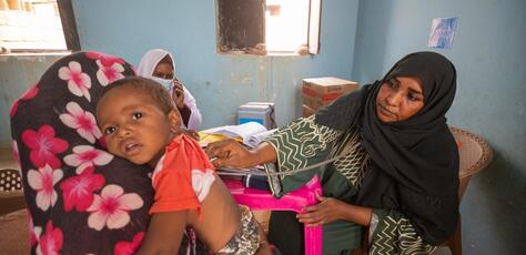 A mother brings her child for treatment at a UNICEF-supported mobile clinic in Adama locality, Atbara, River Nile state, Sudan. 