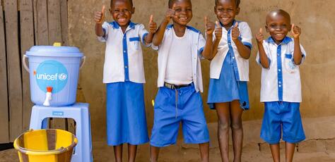 Students at Ecole Primaire Ilako in Mbandaka, Democratic Republic of the Congo, stand outside their classroom after washing their hands. UNICEF installed handwashing stations at the school to help students protect themselves from Ebola.