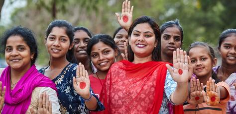 Payal Patel, who has developed a basket of affordable and sustainable menstrual products for women, poses with women and girls in Odisha, India.