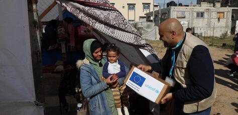 UNICEF Staff members distribute warm clothing to the IDP community in Rafah, southern Gaza Strip.