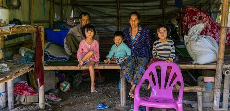 A family displaced by conflict in Kachin State, Myanmar, sits inside their makeshift room at the Shamari IDP camp in Myitkyina, where Deputy Executive Director Ted Chaiban paid a visit to witness impacts of the ongoing humanitarian crisis in the country.