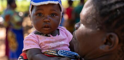 On Jan. 30, 2024, a child is held by her parent at a UNICEF-supported immunization session in Chinkuyu village, Malawi. 