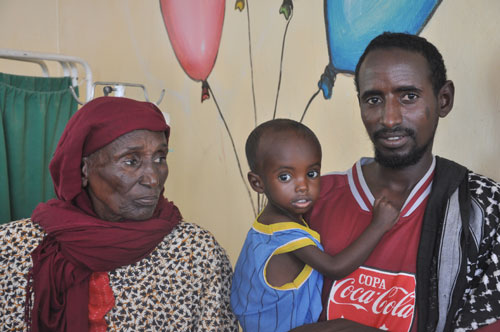 Aden waits with his grandmother and father on the day of his release from the hospital after being treated for severe acute malnutrition